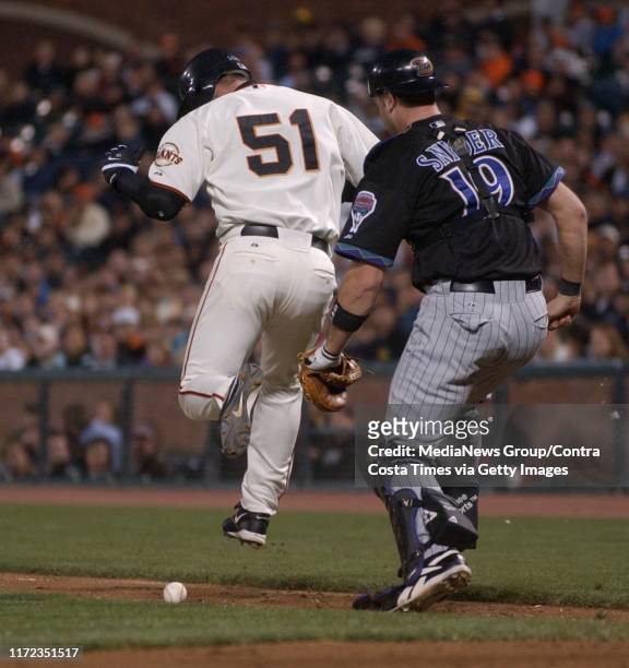 San Francisco Giants pitcher Noah Lowry, #51, leaps over his bunt as Arizona Diamondbacks catcher Chris Snyder, #19, watches the ball stay fair in...