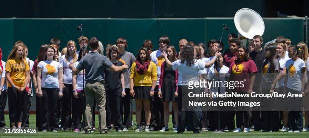 Students of the Las Lomas High School choir and concert band perform the national anthem before the Oakland Athletics vs. Kansas City Royals game at...
