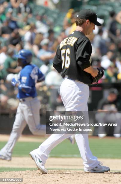 Oakland Athletics' reliever Craig Breslow walks off the mound as Kansas City Royals' Yuniesky Betancourt, <cm-cq> left, rounds third base after...