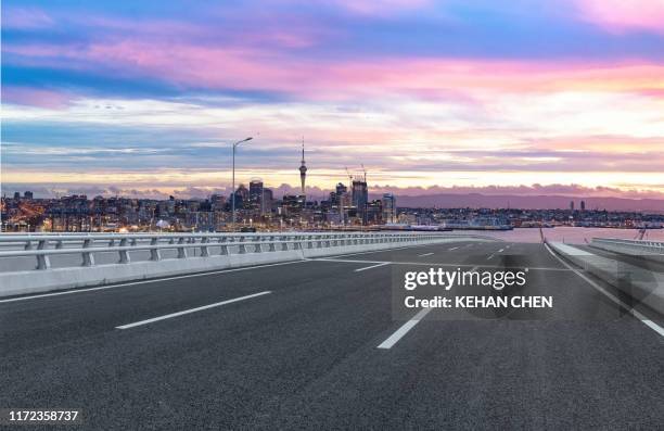 empty tarmac road against sunset urban auckland city - auckland stock-fotos und bilder