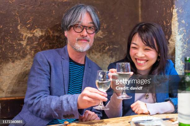 レストランで一緒に夕食を食べる中高年の人々 - 飲み会　日本 ストックフォトと画像