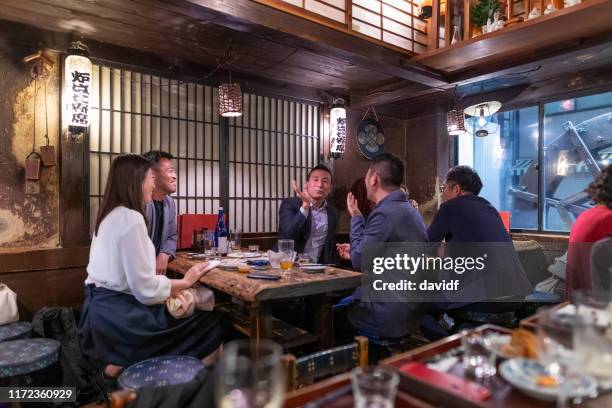 people enjoying a dinner and drinks at a restaurant in tokyo - izakaya stock pictures, royalty-free photos & images