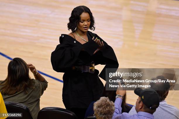 Rihanna gestures while sitting court side during the fourth quarter of Game 1 of the NBA Finals at Oracle Arena in Oakland, Calif., on Thursday, June...