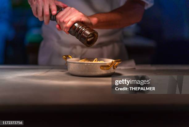 grinding black pepper over pasta dish - condiment stock pictures, royalty-free photos & images