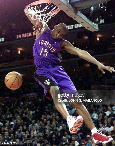 Toronto Raptors player Vince Carter gets his arm tangled in the net during the NBA All-Star Slam Dunk contest 12 February, 2000 at the Arena in...