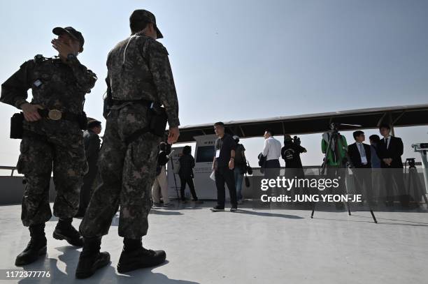 South Korean soldiers stand guard on the rooftop of a building during a press tour to the Taesungdong freedom village, in the Demilitarized zone...