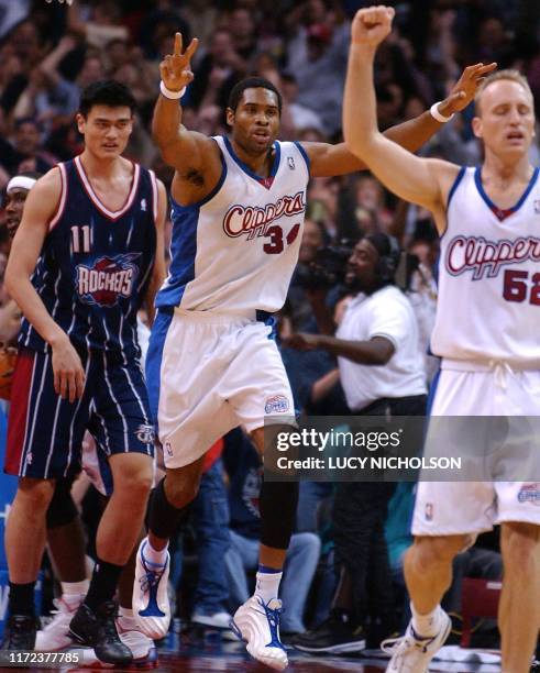 Los Angeles Clippers' Michael Olowokandi raises two fingers in celebration after teammate Eric Piatkowski scored the winning two-pointer in the final...