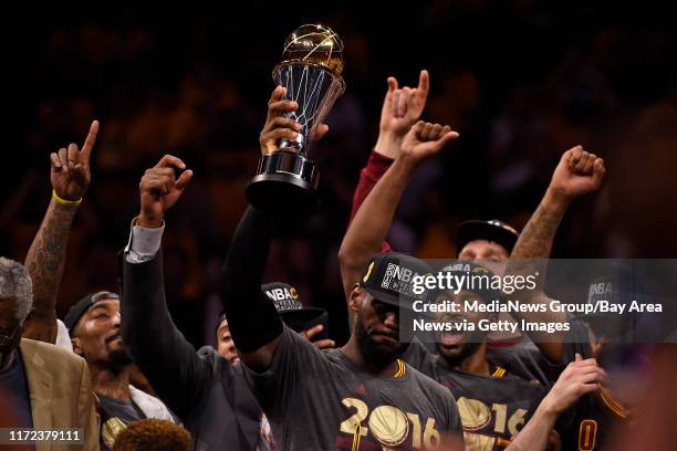 With tears in his eyes Cleveland Cavaliers' LeBron James holds up the MVP trophy after defeating the Golden State Warriors in Game 7 of the NBA...