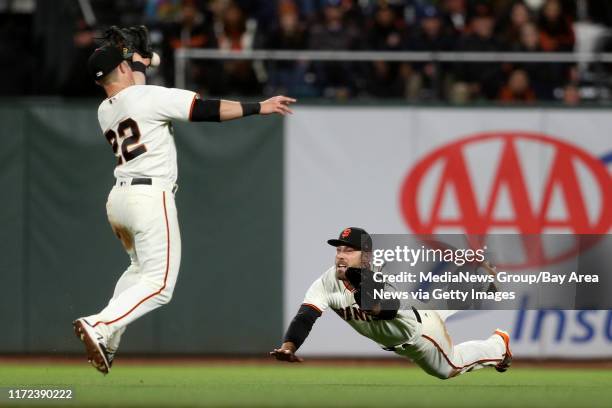 The San Francisco Giants' Christian Arroyo and Mac Williamson can't catch a base hit by the Los Angeles Dodgers' Justin Turner in the eighth inning...