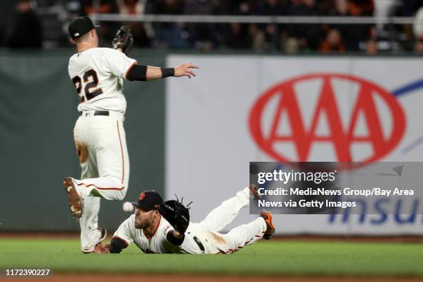 The San Francisco Giants' Christian Arroyo and Mac Williamson can't catch a base hit by the Los Angeles Dodgers' Justin Turner in the eighth inning...