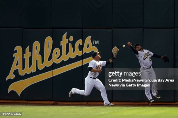 Oakland Athletics' Jake Smolinski and Danny Valencia retrieve the ball on a double hit by Cleveland Indians' &#13;Brandon Guyer in the fifth inning...