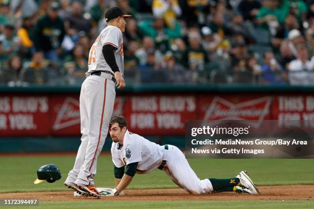 Oakland Athletics' Billy Burns is safe at third on a base hit by Oakland Athletics' Coco Crisp against Baltimore Orioles' iManny Machado n the first...