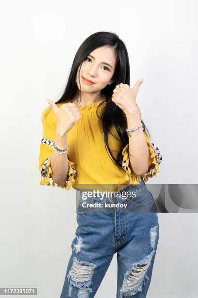 young woman using finger to good symbol on white background. - happy woman thumbs studio ストックフォトと画像