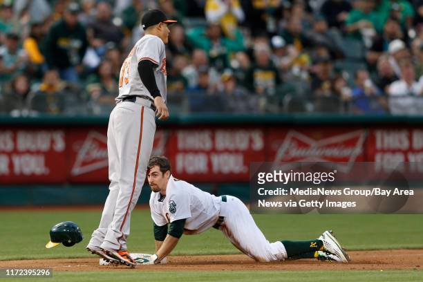 Oakland Athletics' Billy Burns is safe at third on a base hit by Oakland Athletics' Coco Crisp against Baltimore Orioles' iManny Machado n the first...