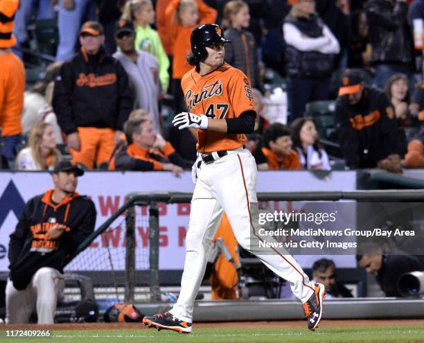 While walking back to the dugout, San Francisco Giant's Jarrett Parker watches the video replay of Arizona Diamondbacks outfielder A.J. Pollock...