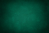 Dark green matt suede fabric closeup. Velvet texture.