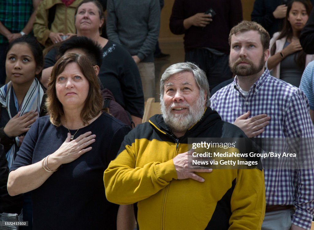 Tech pioneer, Steve Wozniak, with wife, Janet Hill, and attendees stand for the National Anthem during the installation of the official Silicon Valley Comic Con flag at San Jose City Hall in San Jose, Calif., Tuesday, April 18, 2017. The event kicked off