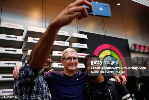 Ali Jangda, of Cupertino, right, takes a selfie with Tim Cook, Apple CEO, center as the new iPhone X goes on sale at the Apple store in Palo Alto,...