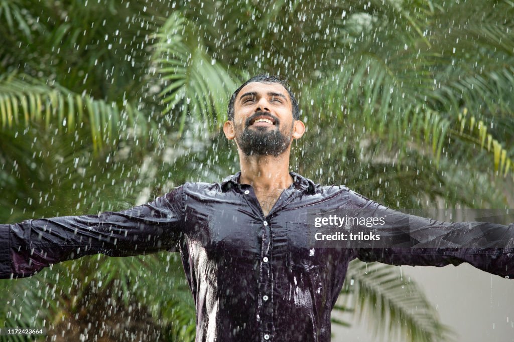 Hombre disfrutando de la lluvia