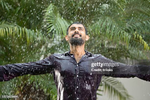 man enjoying rain - rainy season stock pictures, royalty-free photos & images