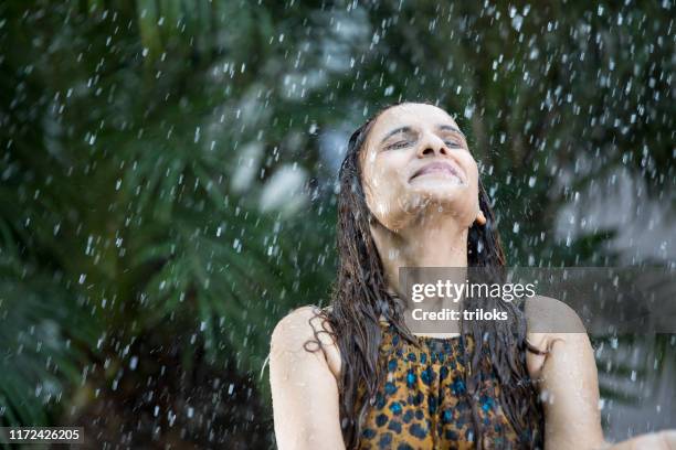 mujer india disfrutando de la lluvia - monzón fotografías e imágenes de stock