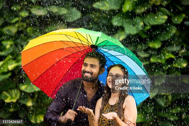 glückliches paar genießt den regen - rainy season stock-fotos und bilder