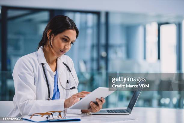 managing her daily medical duties - doctor tablet stock pictures, royalty-free photos & images