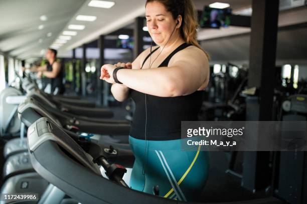 mulheres do excesso de peso na ginástica - treadmill - fotografias e filmes do acervo