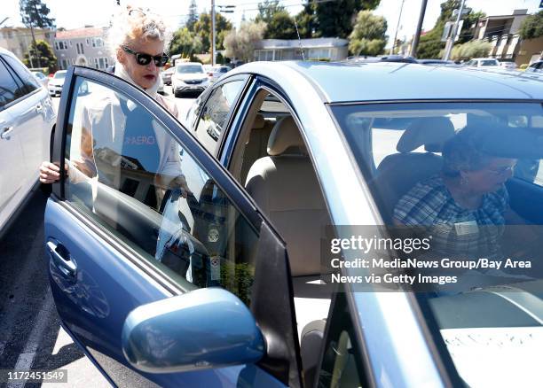 Paula Thompson, left, gets into a car driven by volunteer Barbara Saunders, right, from the Get Up & Go paratransit service after a physical therapy...