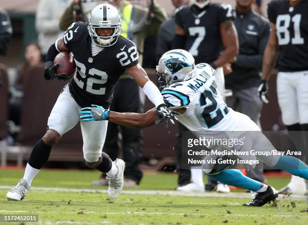 Oakland Raiders running back Taiwan Jones works to get past Carolina Panthers corner back Robert McClain during the first quarter of their game on...