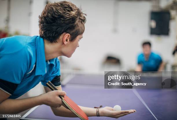 dos mujeres jugando al tenis de mesa - tenis de mesa fotografías e imágenes de stock