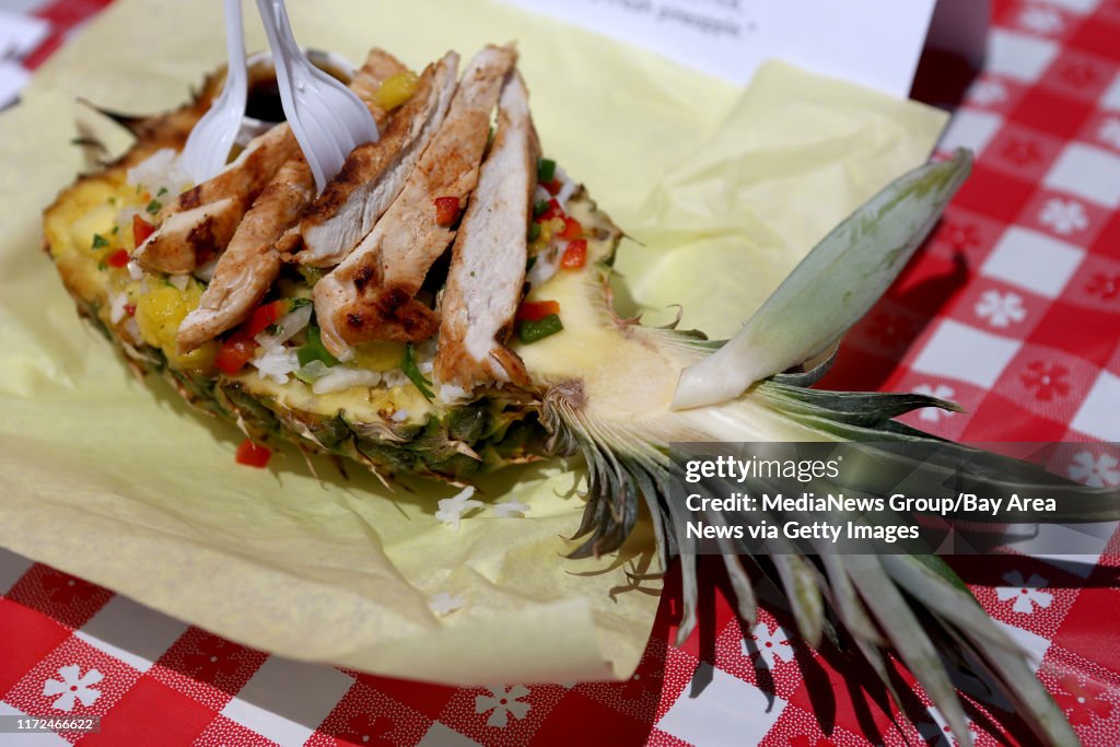 A pineapple chicken and rice bowl, marinated chicken with homemade pineapple salsa and white rice served in half a fresh pineapple created by Shark's Fish Fry on display at the 2017 Snackdown Fryday competition at the Alameda County Fair in Pleasanton, C