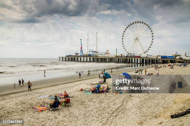 gente durante el día nublado en la playa de atlantic city - atlantic city fotografías e imágenes de stock
