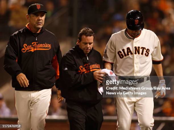 San Francisco Giants manager Bruce Bochy and trainer Dave Groeschner walk off the field with San Francisco Giants' starting pitcher Ryan Vogelsong...
