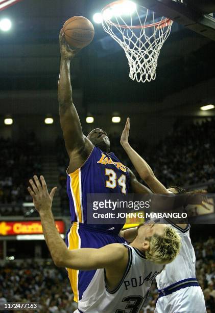 Los Angeles Lakers' Shaquille O'Neal goes over Sacramento Kings' Scot Pollard and Kings' Hedo Turkoglu for two-points while getting fouled by Pollard...