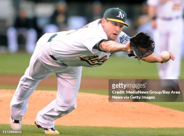 Oakland Athletics pitcher Dallas Braden stretches for the ball hit by Seattle Mariners' Yuniesky Betancourt during the first inning of their baseball...