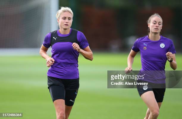 Steph Houghton and Tessa Wullaert of Manchester City Women warm up during a training session at Manchester City Football Academy on September 05,...