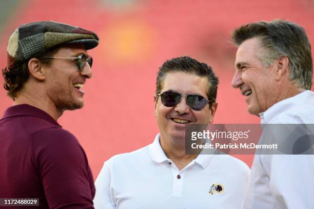 Actor Matthew McConaughey talks with Washington Redskins owner Dan Snyder and Redskins team president Bruce Allen before a preseason game between the...