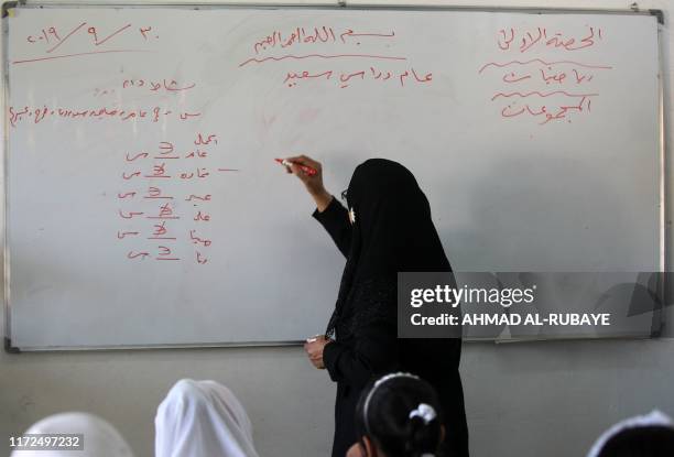 Teacher explains a lesson to her pupils on their first day of school in the Iraqi capital Baghdad on September 30, 2019.