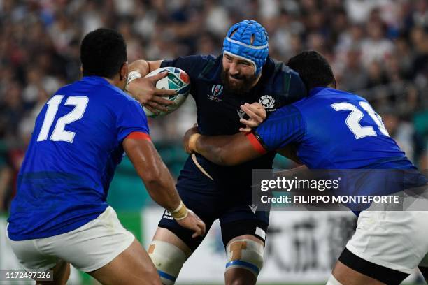 Scotland's number 8 Blade Thomson is tackled by Samoa's back row Josh Tyrell and Samoa's centre Henry Taefu during the Japan 2019 Rugby World Cup...