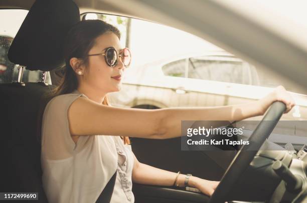 a portrait of a young asian woman in the car driver seat - limousine luxuswagen stock-fotos und bilder