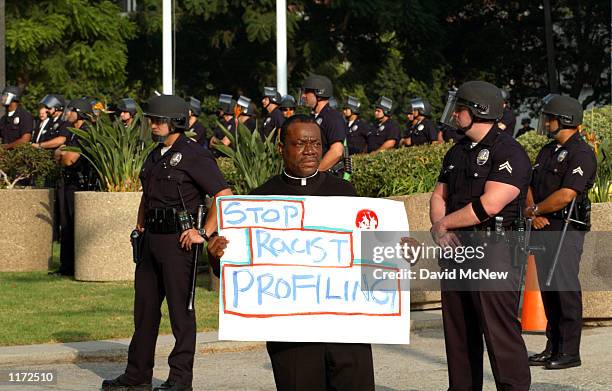 Rev. M. Andrew Robinson-Gaither protests racial profiling by police as he stands near officers surrounding the LAPD Headquarters during the October...