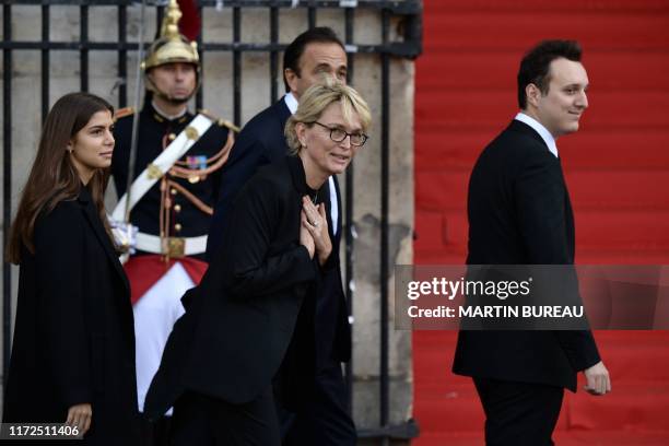 France's former President Jacques Chirac's daughter Claude Chirac waves as she arrives with her son Martin Rey-Chirac and her husband Frederic...