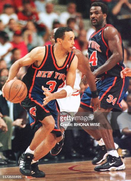 John Starks of the New York Knicks dribbles the ball past Tim Hardaway of the Miami Heat as Charles Oakley from the Knicks looks on during the fifth...
