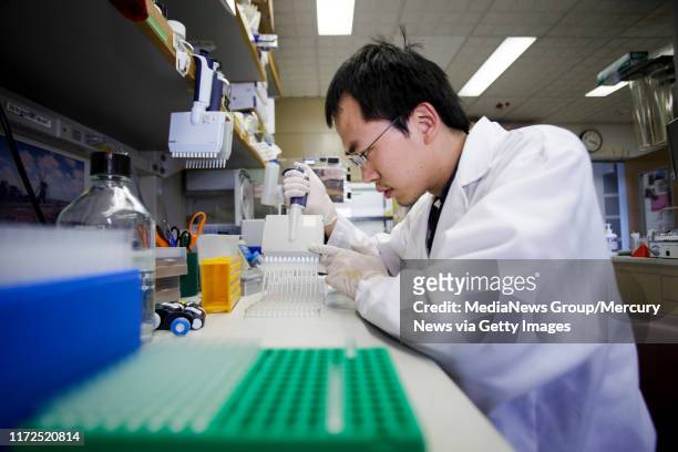 Huang Huang, a postdoctoral fellow and a researcher at Mark Davis' lab at Stanford University School of Medicine, conducts an experiment to measure a...