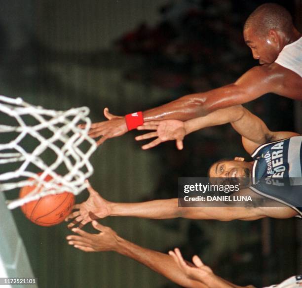 Joelcio Joerke de Brasil intenta encestar ante la marca de dos no identificados rivales de Cuba, 25 agosto en Montevideo, durante el match que...