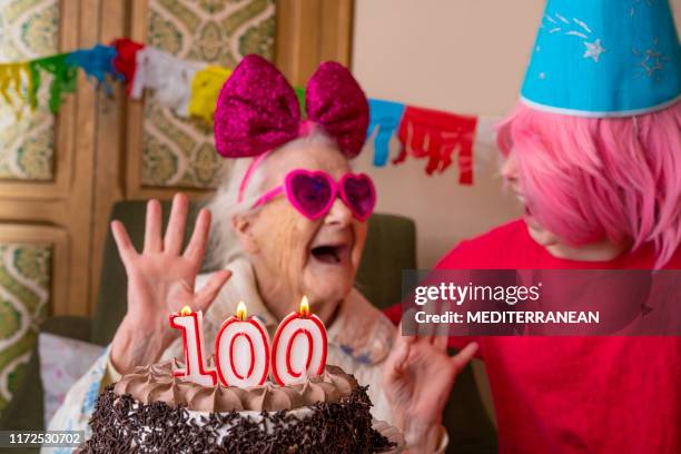 pastel de cumpleaños de 100 años de edad a la anciana de edad avanzada - party retro fotografías e imágenes de stock