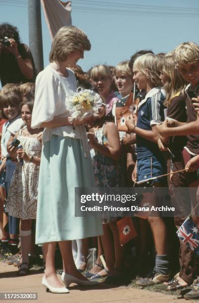 Diana, Princess of Wales visits Tennant Creek in the Northern Territory of Australia, March 1983. Some of the children are holding the flag of the...