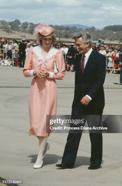 Diana, Princess of Wales chats with Australian Prime Minister Bob Hawke at RAAF Base Fairbairn in Canberra, Australia, March 1983. She is wearing a...