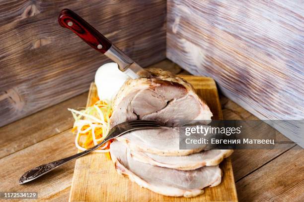 baked pork ham on a chopping board with vegetable spaghetti on a rustic wooden table - braised stock pictures, royalty-free photos & images